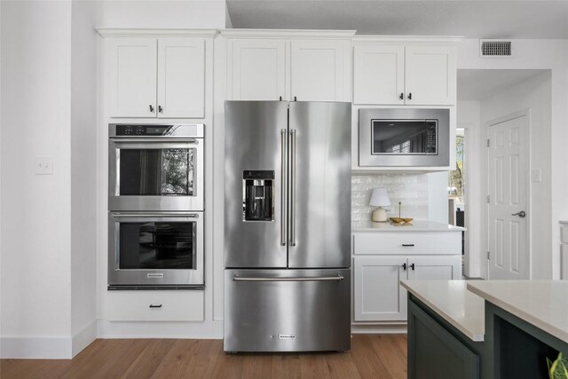 9943 Derecho Dr, Austin, TX 78737 - kitchen featuring appliances with stainless steel finishes, light countertops, dark wood-style floors, white cabinets, and baseboards
