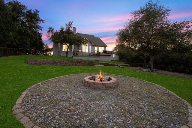 9943 Derecho Dr, Austin, TX 78737 - back of house at dusk with a fire pit and a chimney