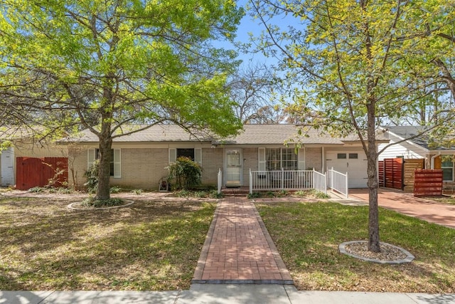 single story home with fence, a front lawn, a porch, brick siding, and a garage