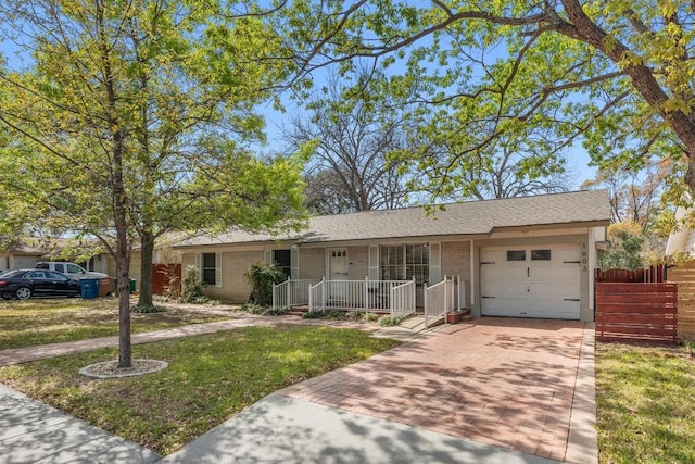 ranch-style home with a front lawn, an attached garage, decorative driveway, a porch, and brick siding