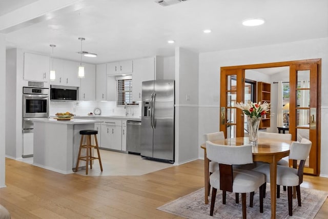 dining room with light wood-style flooring, baseboards, and recessed lighting