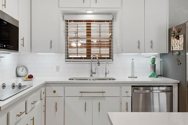 kitchen featuring backsplash, appliances with stainless steel finishes, a sink, and light countertops