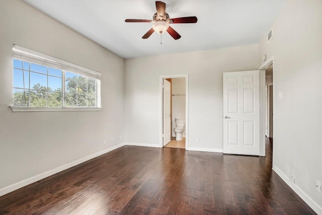 unfurnished bedroom featuring wood-type flooring, baseboards, ensuite bath, and ceiling fan
