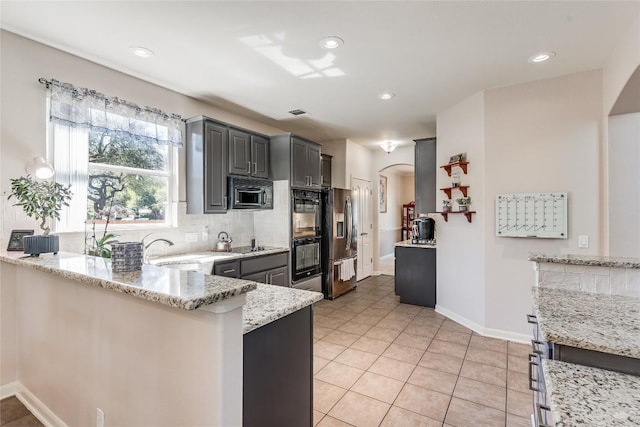 2535 Crenshaw Dr, Round Rock, TX 78664 - kitchen featuring black appliances, arched walkways, a sink, light stone countertops, and recessed lighting