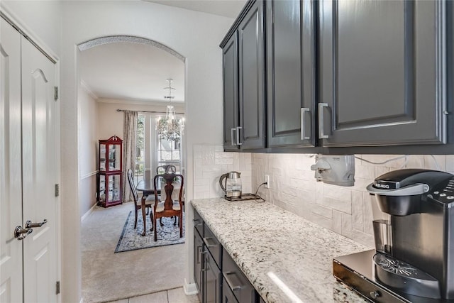2535 Crenshaw Dr, Round Rock, TX 78664 - kitchen featuring light colored carpet, a chandelier, ornamental molding, tasteful backsplash, and light stone counters