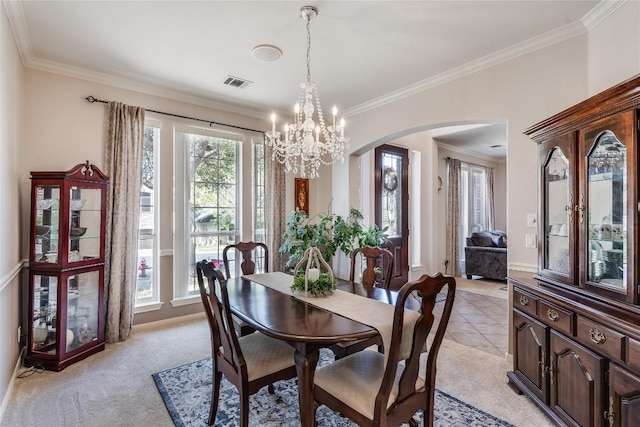 2535 Crenshaw Dr, Round Rock, TX 78664 - dining room featuring arched walkways, ornamental molding, a chandelier, light colored carpet, and baseboards