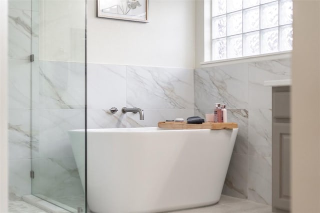 2535 Crenshaw Dr, Round Rock, TX 78664 - full bathroom with tile walls, a soaking tub, and a marble finish shower