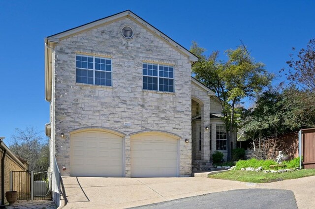 5903 Cane Pace, Austin, TX 78746 - view of front of house featuring stone siding, an attached garage, and concrete driveway