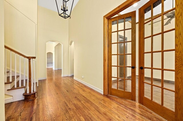5903 Cane Pace, Austin, TX 78746 - foyer with arched walkways, wood finished floors, baseboards, stairway, and french doors