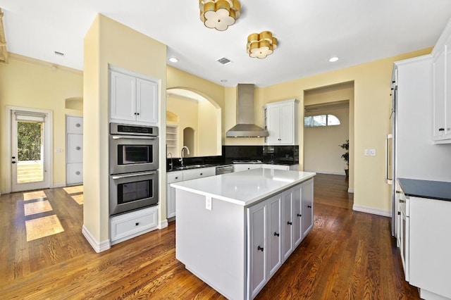 5903 Cane Pace, Austin, TX 78746 - kitchen featuring stainless steel appliances, wall chimney exhaust hood, a kitchen island, white cabinetry, and recessed lighting