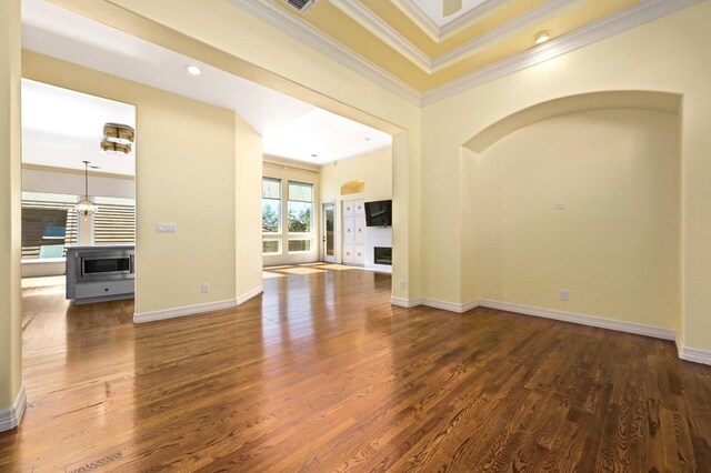 5903 Cane Pace, Austin, TX 78746 - unfurnished living room with crown molding, wood finished floors, baseboards, arched walkways, and recessed lighting