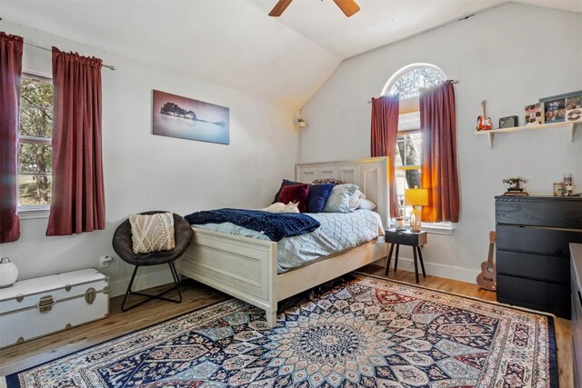 bedroom featuring baseboards, vaulted ceiling, a ceiling fan, and wood finished floors