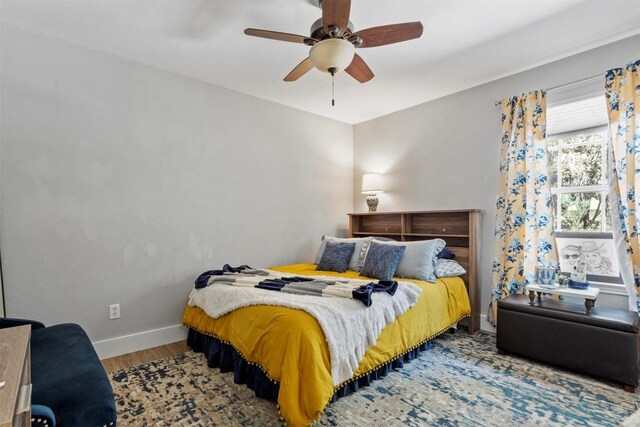 bedroom with baseboards, a ceiling fan, and wood finished floors