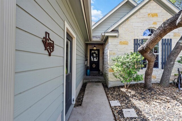 doorway to property featuring stone siding