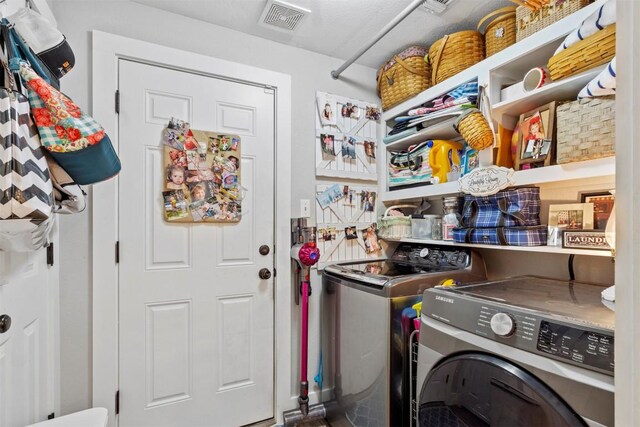 laundry room with laundry area, separate washer and dryer, and visible vents