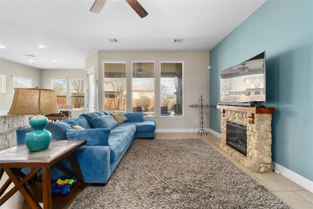 100 Adorno Ln, Georgetown, TX 78628 - living room with light tile patterned flooring, a stone fireplace, baseboards, ceiling fan, and recessed lighting