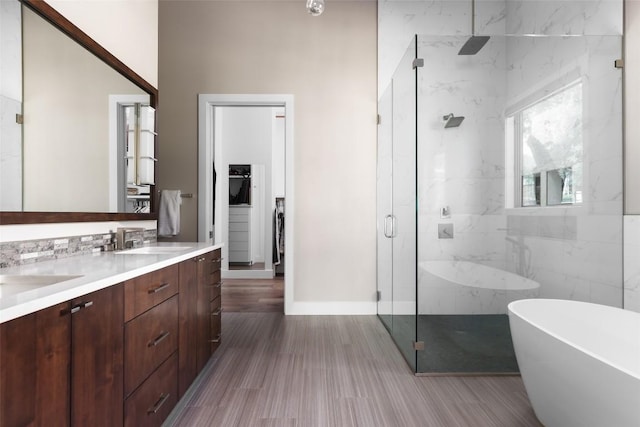 4704 Timberline Dr, Austin, TX 78746 - bathroom with a marble finish shower, double vanity, a freestanding tub, and wood finished floors
