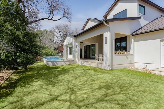 4704 Timberline Dr, Austin, TX 78746 - rear view of property featuring stucco siding, a standing seam roof, ceiling fan, and a yard