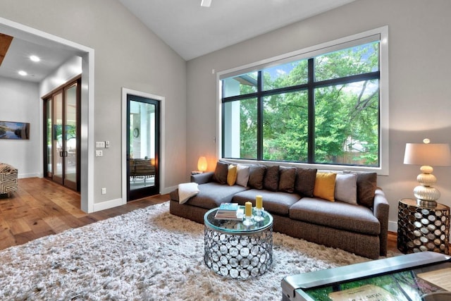 4704 Timberline Dr, Austin, TX 78746 - living room featuring wood finished floors, lofted ceiling, baseboards, and french doors