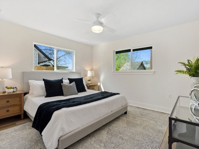 5416 Coventry Ln, Austin, TX 78723 - bedroom with multiple windows, baseboards, wood finished floors, and ceiling fan