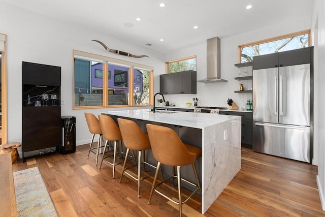 1411 Haskell St, Austin, TX 78702 - kitchen with freestanding refrigerator, wall chimney exhaust hood, recessed lighting, open shelves, and a kitchen breakfast bar