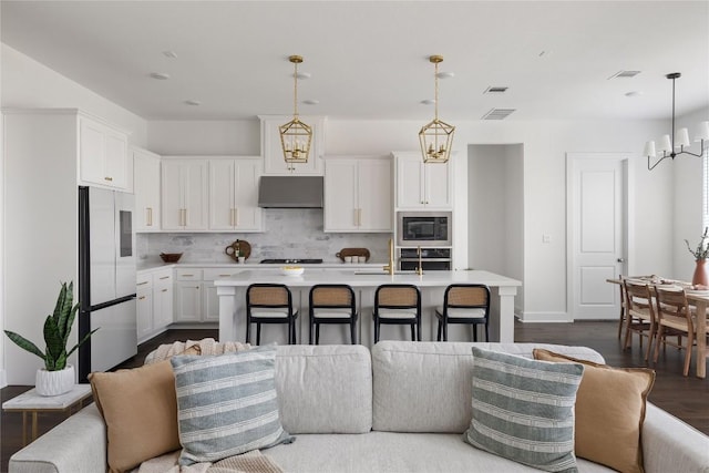 1005 Trevi Fontana, Leander, TX 78641 - kitchen with stainless steel appliances, under cabinet range hood, light countertops, a chandelier, and backsplash