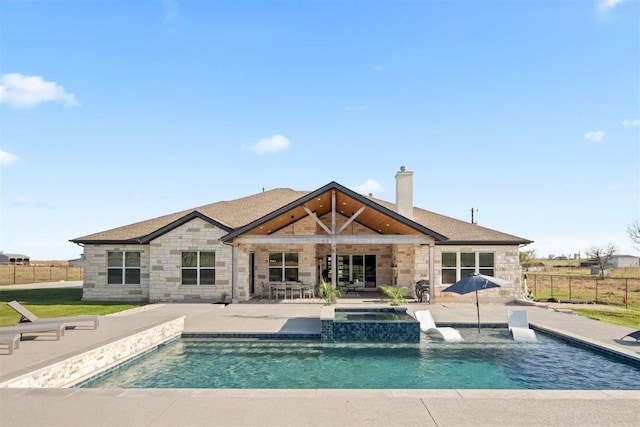 425 Private Road 915, Georgetown, TX 78633 - back of house featuring a chimney, stone siding, fence, a patio, and a pool with connected hot tub