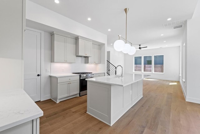 710 Philco Dr, Austin, TX 78745 - kitchen featuring gas stove, ceiling fan, backsplash, and light wood-style floors