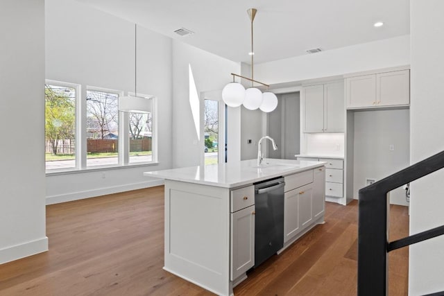 710 Philco Dr, Austin, TX 78745 - kitchen featuring a sink, wood finished floors, dishwasher, hanging light fixtures, and visible vents