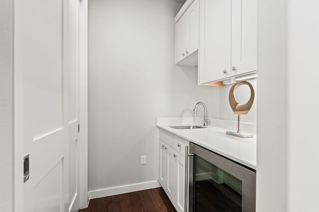 316 Hidden Beacon Bnd, Lakeway, TX 78738 - washroom featuring beverage cooler, a sink, baseboards, and dark wood-type flooring