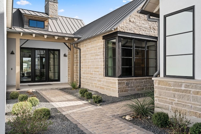316 Hidden Beacon Bnd, Lakeway, TX 78738 - doorway to property with a standing seam roof, a metal roof, a chimney, french doors, and brick siding
