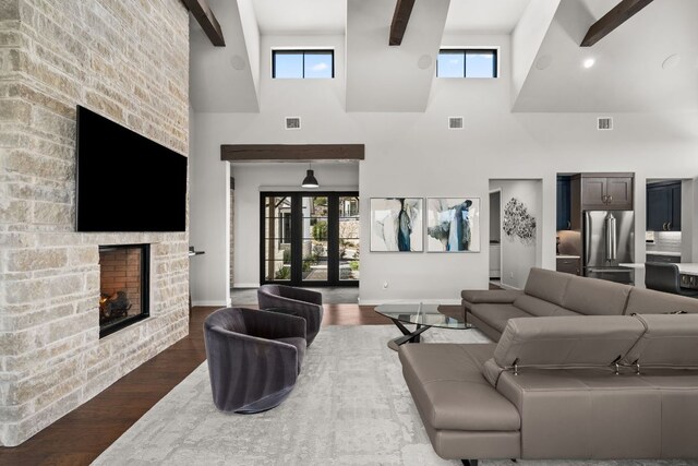 316 Hidden Beacon Bnd, Lakeway, TX 78738 - living room featuring a high ceiling, a stone fireplace, dark wood finished floors, and plenty of natural light