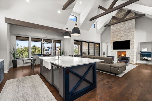 316 Hidden Beacon Bnd, Lakeway, TX 78738 - kitchen with a sink, light countertops, beam ceiling, hanging light fixtures, and a stone fireplace