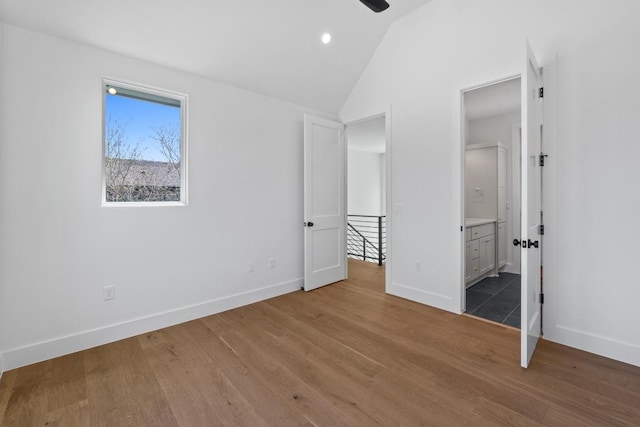 4525 S 3rd St, Austin, TX 78745 - unfurnished bedroom with lofted ceiling, wood finished floors, ensuite bathroom, and recessed lighting
