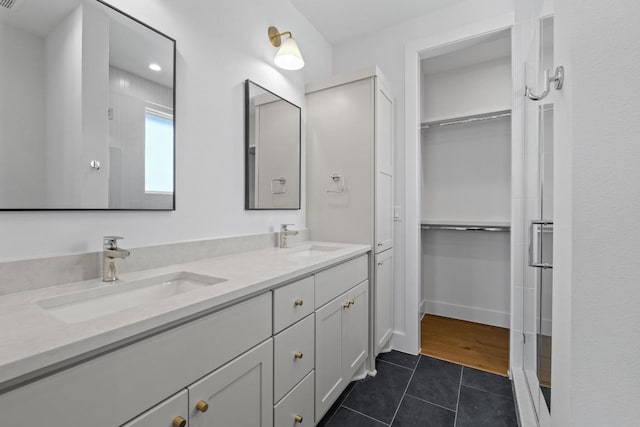 4525 S 3rd St, Austin, TX 78745 - bathroom with tile patterned floors, double vanity, and a walk in closet