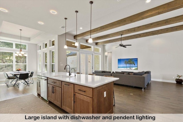 145 Gaston Dr, Bastrop, TX 78602 - kitchen featuring an island with sink, light countertops, dark wood finished floors, a sink, and hanging light fixtures