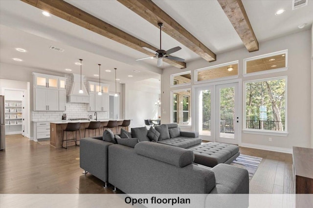 145 Gaston Dr, Bastrop, TX 78602 - living room featuring a ceiling fan, beamed ceiling, dark wood finished floors, baseboards, and visible vents