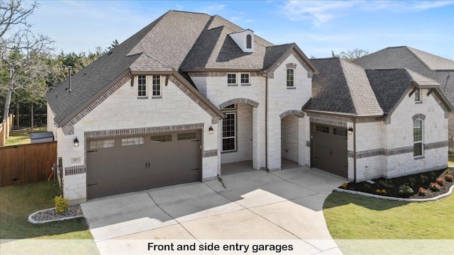 145 Gaston Dr, Bastrop, TX 78602 - french country style house featuring a garage, driveway, and stone siding