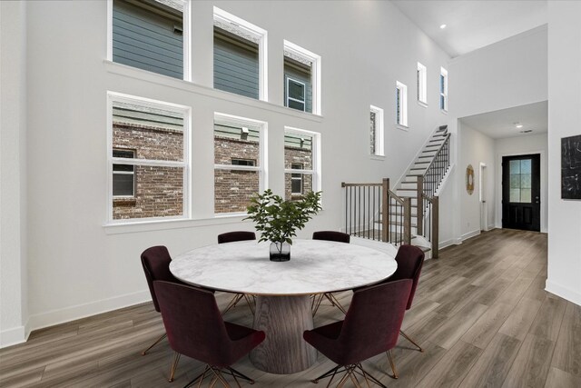 1405 S Brook Dr, Leander, TX 78641 - dining space featuring a towering ceiling, stairs, wood finished floors, and recessed lighting