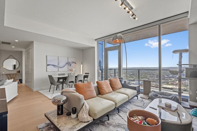 44 E Ave Unit 3402, Austin, TX 78701 - living area with a wall of windows, wood finished floors, baseboards, and track lighting