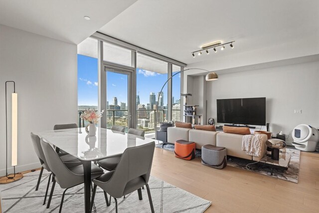 44 E Ave Unit 3402, Austin, TX 78701 - dining room with light wood finished floors and a wall of windows