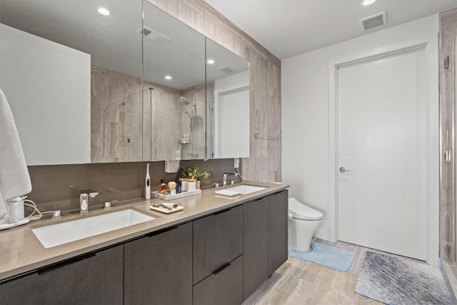 44 E Ave Unit 3402, Austin, TX 78701 - bathroom featuring a stall shower, double vanity, toilet, and recessed lighting
