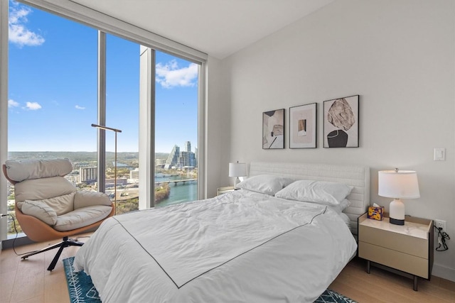 44 E Ave Unit 3402, Austin, TX 78701 - bedroom with expansive windows, wood finished floors, and a city view