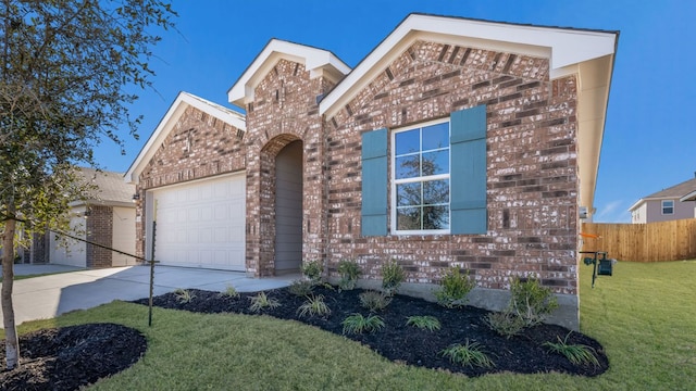 view of front facade featuring fence, a front lawn, brick siding, a garage, and driveway