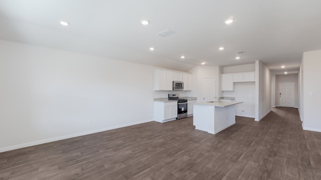 kitchen featuring baseboards, open floor plan, an island with sink, white cabinets, and stainless steel appliances