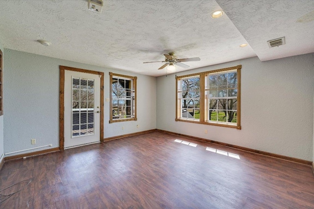 spare room with a textured ceiling, baseboards, a ceiling fan, and wood finished floors