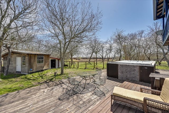 wooden deck with a hot tub, an outdoor structure, and outdoor dining space
