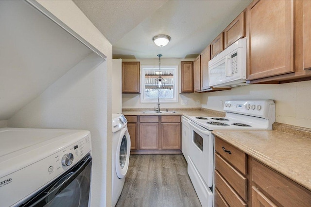 kitchen featuring white appliances, a sink, light wood-style floors, and light countertops