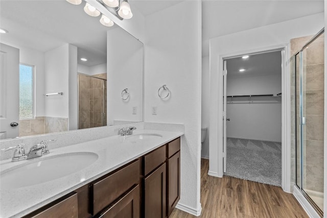 130 Carmello, Kyle, TX 78640 - bathroom featuring a shower stall, a spacious closet, double vanity, wood finished floors, and recessed lighting
