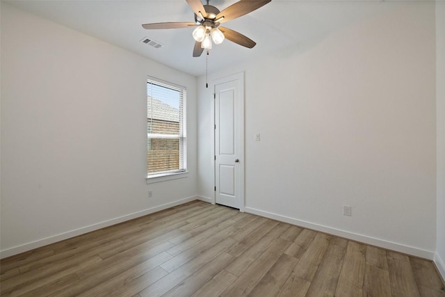 unfurnished room with baseboards, light wood-style floors, and a ceiling fan